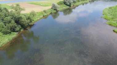 Tarım arazileri ve yemyeşil alanlarla çevrili kırsal bir nehrin havadan bakış açısı.