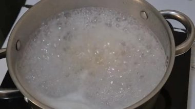 Güneşin doğuşunda tepelerde yuvarlanan bulutlarla karla kaplı dağların nefes kesen manzarası..