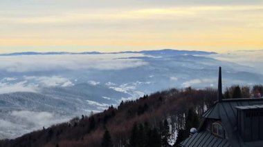Güneşin doğuşunda yuvarlanan bulutlarla kaplı sisli sıradağların hava görüntüleri..