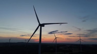 Kırsal ufuktaki rüzgar türbinlerinin insansız hava aracı görüntüsü, sürdürülebilirliğin ve temiz gücün yenilenebilir enerji endüstrisi sembolü.