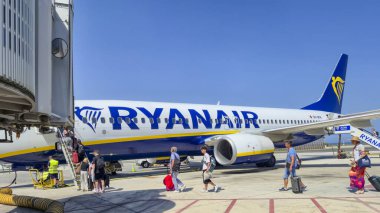 Alicante Spain - July 17 2025: Passengers boarding a Ryanair airplane at the airport on a sunny day showcasing air travel and vacation enthusiasm.