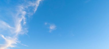 Birkaç ince bulutlu açık mavi bir gökyüzü sakin bir atmosfer yaratır. Bu görüntü sükuneti iletir ve doğa havasına veya barışa odaklanan projeler için idealdir..