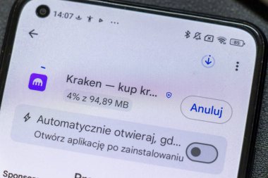 Warsaw Poland - September 24 2025: A close-up of a smartphone screen displaying the Kraken app download progress indicating 4% completion on a background of notification settings.