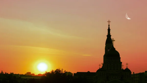 The image of the sunset and against the backdrop of the sunset the building of the church
