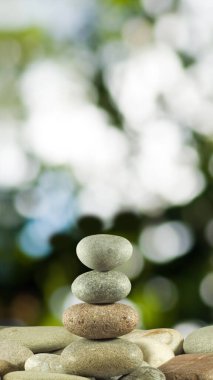 Yeşil zemine karşı taş piramitler sakinliğin ve dengenin sembolüdür. Zen meditasyon kavramı.