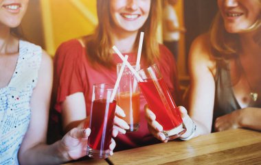 Sağlıklı içecekler, gülümseyen ve tezahürat yapan bir grup insan kafeteryada meyve suyu bardaklarıyla.