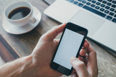 mobil uygulama, boş beyaz ekranlı akıllı telefonu tutan ellere yakın çekim