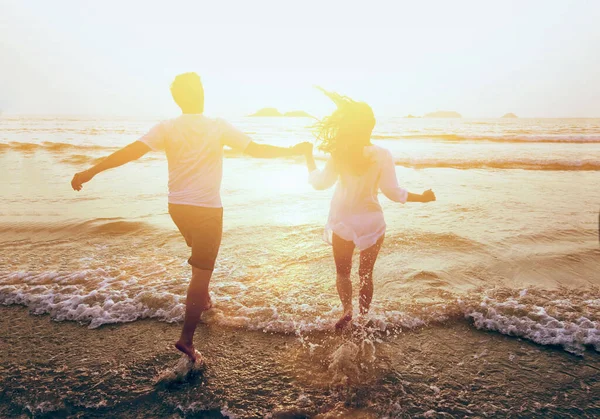 ビーチで海に走っている若い幸せなカップル夏休み旅行 — ストック写真