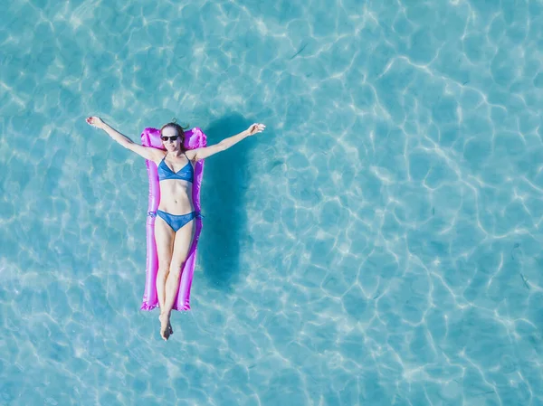 休暇中の幸せな女性観光客ビーチでの夏休み海のターコイズブルーの水のマットレスに浮かぶビキニの女の子 — ストック写真
