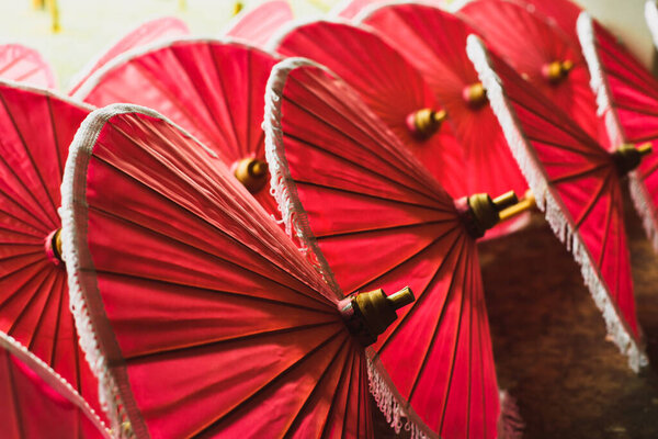 red paper fabric traditional asian umbrellas for sale on street market in Asia