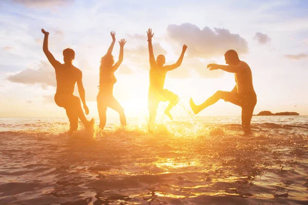 夕阳西下 成群的朋友在水里玩乐 快乐的人们享受暑假的轮廓 — 图库照片