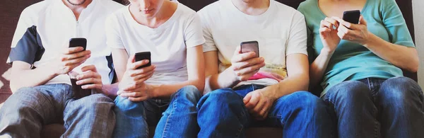 Группа Подростков Сидящих Вместе Смотрят Свои Смартфоны Молодых Людей Мобильниками — стоковое фото