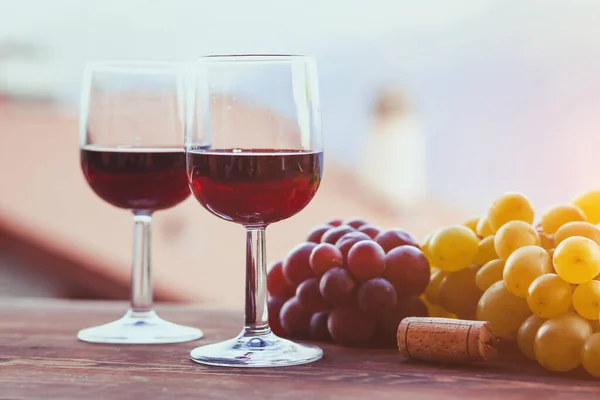 赤ワインとブドウの2つのグラスコピースペースの背景 — ストック写真