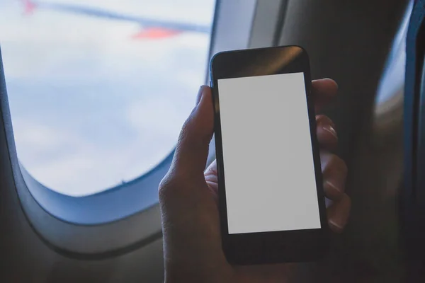 Trzymanie Smartfona Samolocie Pomocą Telefonu Komórkowego Pustym Ekranem Samolocie — Zdjęcie stockowe