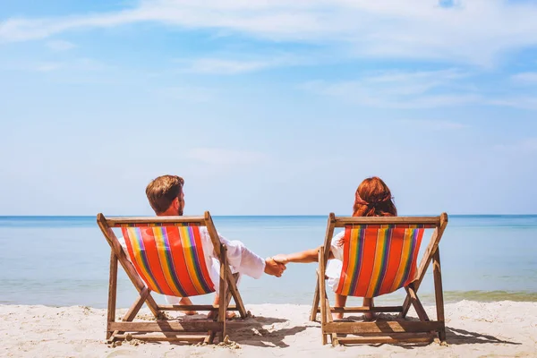 パラダイスビーチのデッキチェアに座っているカップル抽象的なホテルロマンチックな休暇旅行 — ストック写真