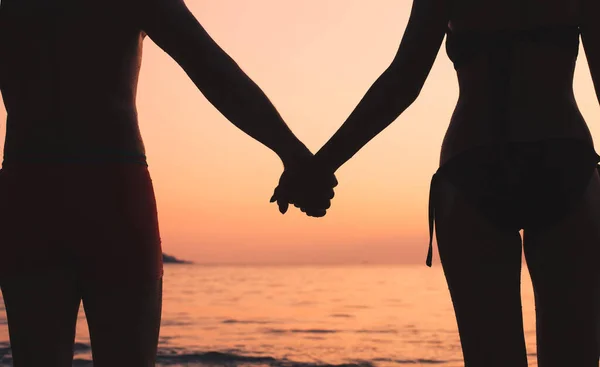 浪漫的旅行 沙滩上的情侣 夕阳西下牵着手的男女轮廓 — 图库照片