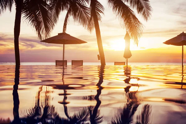 ヤシの木熱帯の風景エキゾチックな島のホテルを反映して日没のビーチスイミングプール — ストック写真