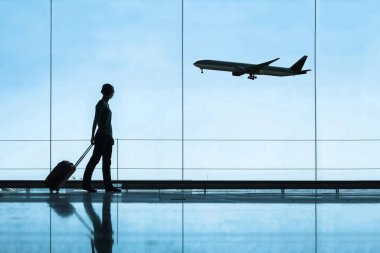 Havaalanında valiz, seyahat ve turizm konseptiyle seyahat eden kadın silueti, uçak biletleri.