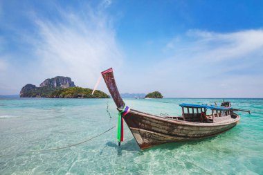 Tayland 'da Krabi ve Phuket arasında güzel bir ada manzarası var. Turkuaz cennet suyunda geleneksel ahşap uzun kuyruklu tekneyle seyahat ediyorlar.