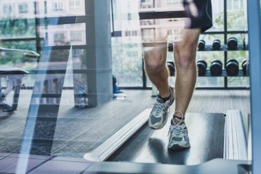 Koşu bandında ayak koşusu, fitness merkezinde spor egzersizleri, antrenman eğitimi, koşu pistinde koşan adam.