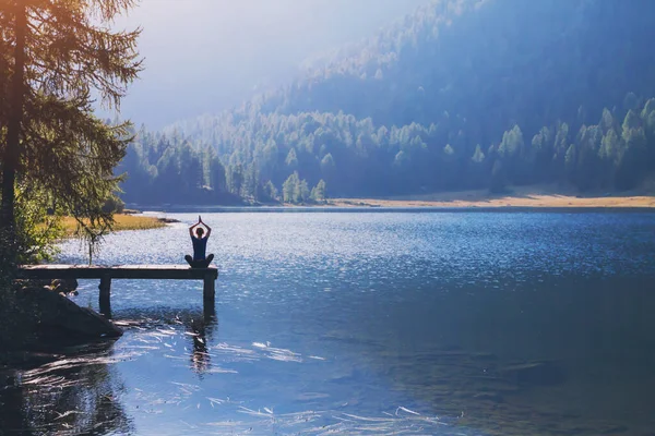 瑜伽优美的背景 和谐的生活 冥想的练习 在湖畔的荷花位置上坐着的女人的轮廓 在美丽的风景中做呼吸练习 — 图库照片