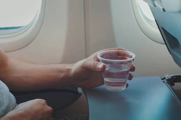 Woda Pitna Dla Pasażerów Samolocie Podczas Lotu Zbliżenie Ręcznego Szkła — Zdjęcie stockowe