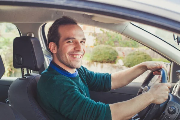 車の中で幸せなドライバの肖像画 運転免許を取得したカメラを見て笑顔の若者 — ストック写真
