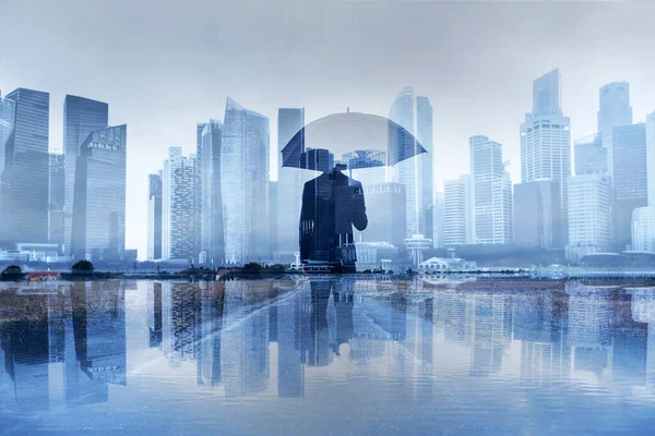 保险概念 商业风险 有保护伞双重风险的商人 图库照片