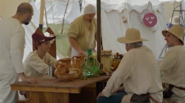 Scenes in medieval costume, peasants eating under a tent in a medieval camp on June 21, 2022 in Morimondo, Italy