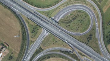 Otoyol kavşağının üstünden hava görüntüsü. Zaman aşımı trafiği. Kuzey İtalya karayolu yazın güneşli bir günde yeşil tarlalarla çevrili..