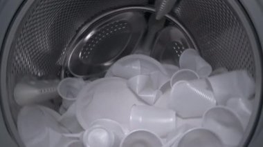 Varili plastik şişelerle dolduran bir ev kadınının çamaşır makinesinin içinden bak. Yeşil ekran, alfa kanallı siyah arkaplanda izole edilmiş. Plastik ve ekolojinin geri dönüşümü kavramı. Plastik atık.