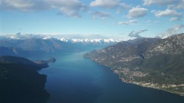 Como Gölü 'nün havadan görünüşü, güneyden panoramik olarak Mandello del Lario şehrinden geçen ve arkasında kar örtülü dağlardan geçen İsviçre Alpleri..