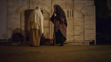 29 Mart 2024 'te İtalya' nın Antignano kentinde, Via Crucis 'in (Haç Yolu) temsili sırasında nüfus pazarda koşuştururken haç sepetleri ören karakterlerle, Kudüs şehrindeki günlük yaşamın yeniden canlandırılması.