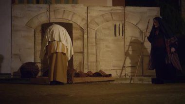 29 Mart 2024 'te İtalya' nın Antignano kentinde, Via Crucis 'in (Haç Yolu) temsili sırasında nüfus pazarda koşuştururken haç sepetleri ören karakterlerle, Kudüs şehrindeki günlük yaşamın yeniden canlandırılması.