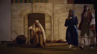 29 Mart 2024 'te İtalya' nın Antignano kentinde, Via Crucis 'in (Haç Yolu) temsili sırasında nüfus pazarda koşuştururken haç sepetleri ören karakterlerle, Kudüs şehrindeki günlük yaşamın yeniden canlandırılması.