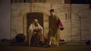 29 Mart 2024 'te İtalya' nın Antignano kentinde, Via Crucis 'in (Haç Yolu) temsili sırasında nüfus pazarda koşuştururken haç sepetleri ören karakterlerle, Kudüs şehrindeki günlük yaşamın yeniden canlandırılması.