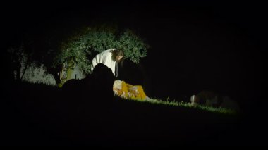 İsa Gethsemane Bahçesi 'nde dua ederken, havariler 29 Mart 2024' te İtalya 'nın Antignano kentinde Haç Yolu' nun temsili sırasında dinleniyorlar.