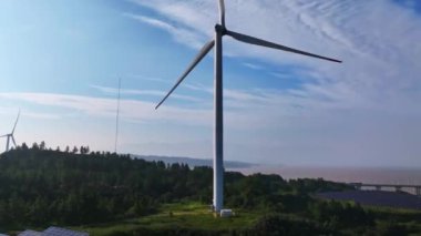 Kırsal kesimdeki güneş panelleri ve rüzgar türbinlerinin hava görüntüsü, yenilenebilir enerji kaynağı