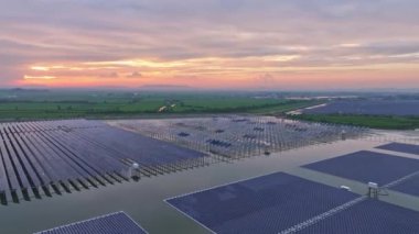Göl suyunun üzerine kurulmuş güneş panelleri, hava manzarası. Kırsal kesimin inanılmaz günbatımı manzarası