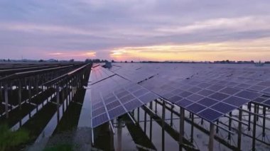 Kırsal alandaki güneş panelleri ve dramatik günbatımı gökyüzü manzarası