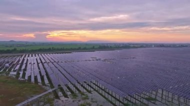 Güneş panellerinin günbatımında sahadaki hava görüntüsü