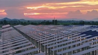 Kırsal alandaki güneş panelleri ve dramatik günbatımı gökyüzü manzarası