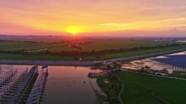 Göl suyunun üzerine kurulmuş güneş panelleri, hava manzarası. Kırsal kesimin inanılmaz günbatımı manzarası
