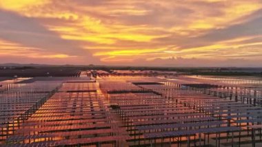 Kırsal alandaki güneş panelleri ve dramatik günbatımı gökyüzü manzarası