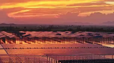 Göl suyunun üzerine kurulmuş güneş panelleri, hava manzarası. Kırsal kesimin inanılmaz günbatımı manzarası