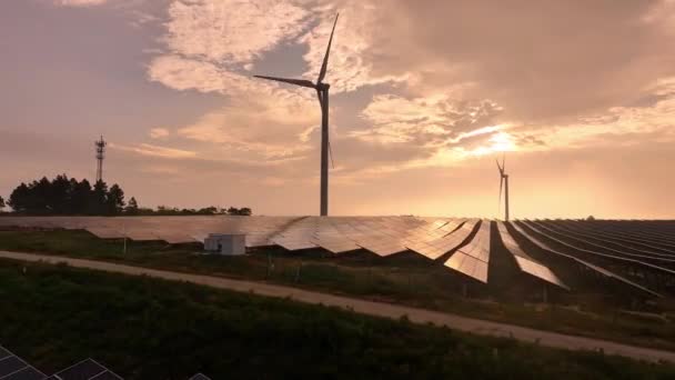 田舎の太陽光パネルと風力タービンの空中日没ビュー 再生可能エネルギー源 — ストック動画