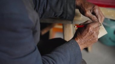 Bir erkek marangoz Çin kırsalındaki geleneksel parçacık tahtasından aletler yapar, el sanatları meraklısıdır.