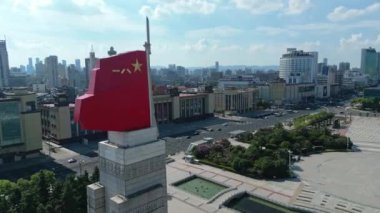 Modern şehirde Çin bayrağı taşıyan heykel