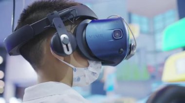Çocuk Çin 'deki Odern Teknoloji Sergisi sırasında VR kulaklık kullanıyor.