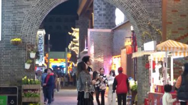 İnsanlar geceleri Asya şehrinde yürüyorlar.